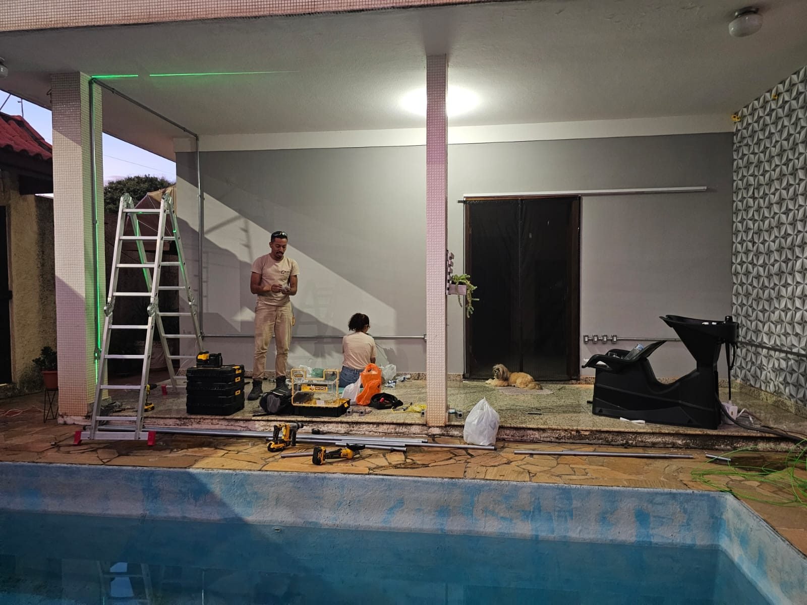 Iluminação externa energizada em área de piscina após execução da instalação