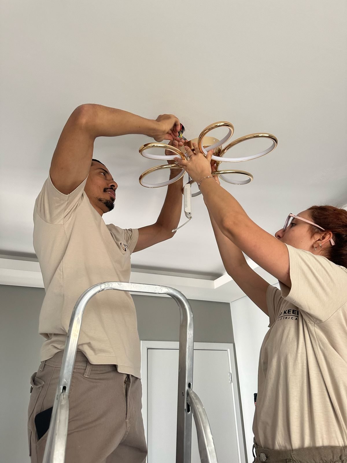 Instalação de luminária no teto durante execução de obra residencial